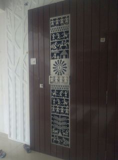 an open door with decorative designs on the front and side panels, in a room with white walls