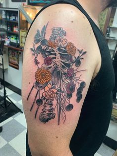 a man with a tattoo on his arm and flowers in the middle of his arm