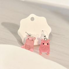 two little pink bears are hanging from earrings