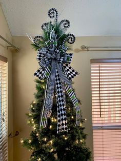 a christmas tree decorated with black and white bows