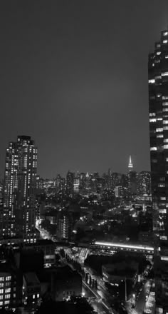 black and white photo of city at night with skyscrapers in the foreground, new york