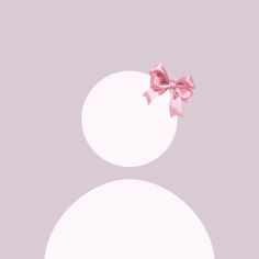 a pink bow on top of two white circles with one smaller circle in the middle