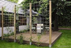 a house with a metal fence around it and some plants growing on the decking