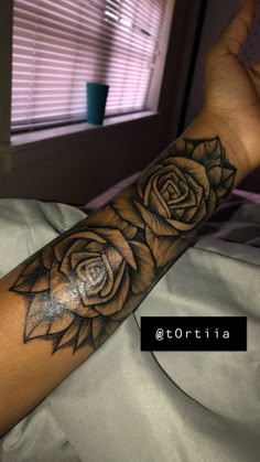 a woman's arm with a rose tattoo on it and the word love written in black ink