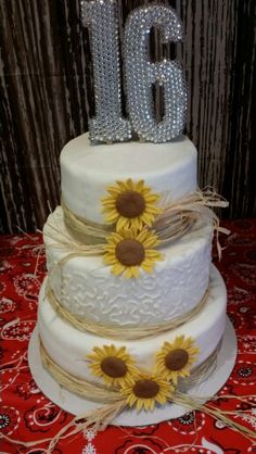 a three tiered cake with sunflowers and the number 16 on it's side