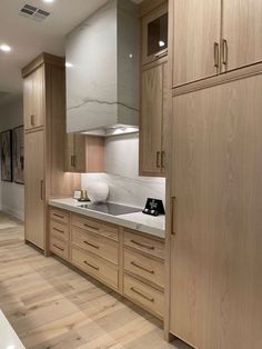 an empty kitchen with wooden cabinets and white counter tops on the walls, along with hardwood flooring