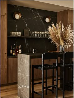 a modern kitchen with marble counter tops and bar stools next to the dining room table