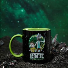 a green and black coffee mug sitting on top of a rock with the words rick in it