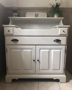 a white dresser with drawers on top of it