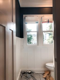 a white toilet sitting next to a window in a bathroom under construction on the floor