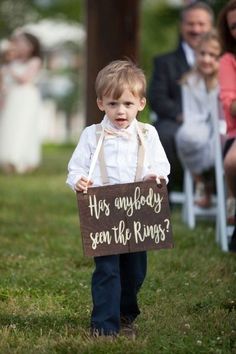 a little boy holding a sign that says, has anybody seen the ring?