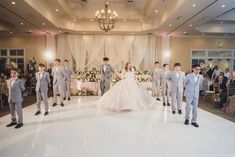 a bride and groom walk down the aisle at their wedding reception in front of an audience