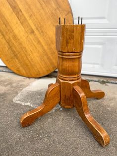 a wooden table with two legs on the ground next to a door and a round object