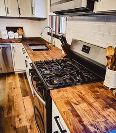 a kitchen with an oven, stove and counter tops made from wooden planks is pictured in this image