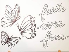 a sign that says faith over fear with two butterflies on it and the words faith over fear written in black ink