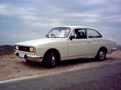 an old car is parked on the side of the road