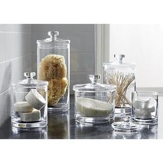 several glass containers with different types of items in them sitting on a counter next to each other