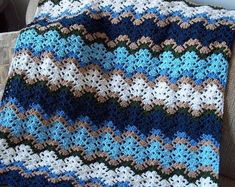 a crocheted blanket sitting on top of a couch