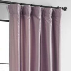 purple curtains hanging on a curtain rod in front of a window with white walls and windowsill