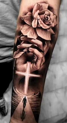 a cross and rose tattoo on the arm with an image of a person holding a flower