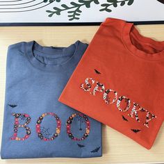 two t - shirts with the word boo spelled out on them next to each other