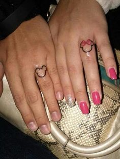 two people with matching rings on their fingers holding onto each other's hands,