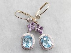 Easily transition from bridal to everyday wear with style in these lovely drop earrings! We've set amethyst floral drops with glittering diamond halos set with heavenly blue topaz gemstones, making a one of a kind pair of earrings that are the perfect gift for the bride to be! Metal: 14K White Gold, 18K White Gold Gem: 2 Blue Topaz Gem Measurements: 6.2 x 8.0 mm, Rectangle Cushion Cut Accents: 8 Amethyst, 48 Diamonds totaling .24 Carats, G in Color, VS in Clarity Earrings Length: 37 mm Earrings Gold Earrings Bridal, Rectangle Cushion, Gift For The Bride, Halo Setting, Diamond Glitter, Diamond Drop Earrings, White Gold Earrings, Diamond Drops, Bride To Be