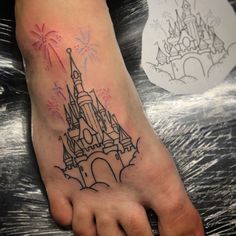 a foot with a castle on it and fireworks in the sky behind it, as well as an outline of a person's feet