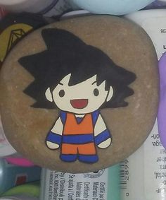 a cartoon character painted on a rock next to other rocks and paperweights,