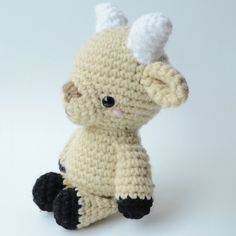 a crocheted stuffed animal sitting on top of a white table next to a wall