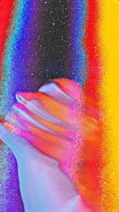 an image of a person's hand with colored powder on it