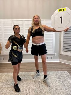 a man and woman in costume standing next to each other holding up a weight scale