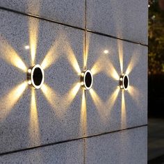 four lights on the side of a wall with three circles and one circle in the middle