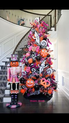 a decorated halloween tree in front of a staircase