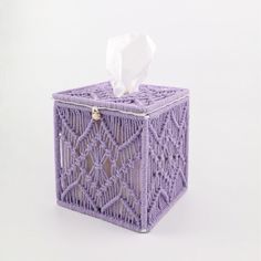 a tissue dispenser made out of purple yarn