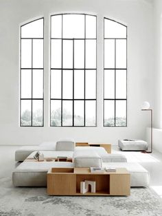 a modern living room with large windows and white furniture