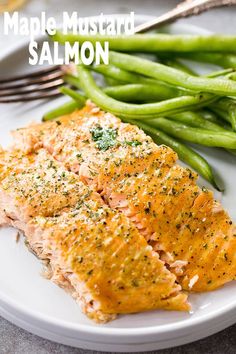 a white plate topped with salmon and green beans