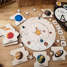 the wooden puzzles have different planets and their names on them, along with space themed magnets