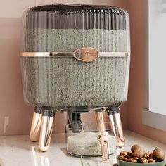 a large glass container sitting on top of a counter next to nuts