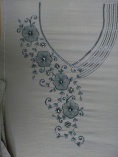 a white shirt with flowers and beads on it