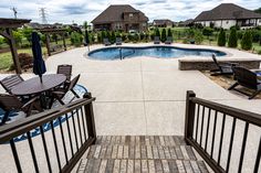 an outdoor swimming pool surrounded by patio furniture