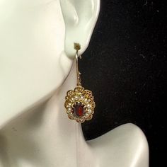 One Pair Art Deco Style 10k Yellow Gold Dangle Earrings. A Sinuous Margin Filigree Frame Basket Setting One Oval Cut Garnet, 8.8 X 6.8mm, It Surrounds Twelve (12) 2.0mm Seed Pearls. Lever Backing. The Setting Is 18mm X 13.6mm. Hanging Length Is 1 3/8" Long. Weight 4.1gm, Hallmark 10k Oval Filigree Earrings For Wedding, Ornate Yellow Gold Oval Earrings, Victorian Jewelry With Oval Matching Earrings, Gold Oval Earrings With Elegant Design, Elegant Oval Gold Earrings, Yellow Gold Oval Filigree Earrings, Oval Yellow Gold Filigree Earrings, Victorian Oval Earrings For Anniversary, Heirloom Oval Gold Earrings