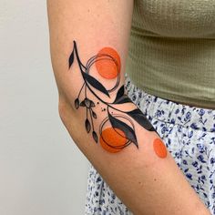 a woman with an orange and black tattoo on her arm