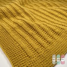 a yellow knitted blanket sitting on top of a white table