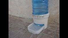 a water dispenser on the side of a building with a large plastic bottle attached to it