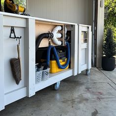 a garage with tools and cleaning equipment in the storage compartment on the side of the building