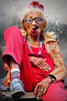 an old woman sitting on a bench with her feet up in front of her face