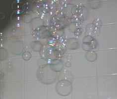 soap bubbles floating in the air on a tiled wall