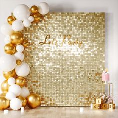 a gold and white party backdrop with balloons