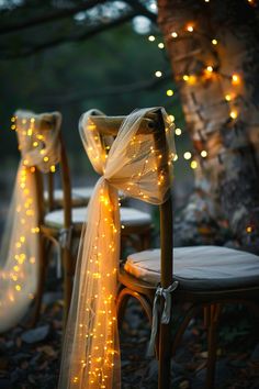 two chairs with lights on them and one chair is covered in a white sheer ribbon